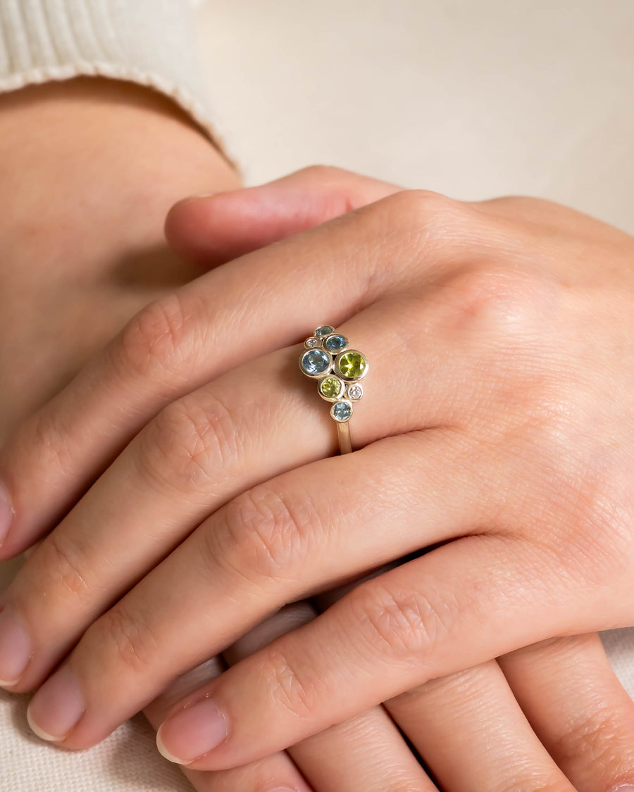 Gold cluster ring with aquamarine, peridot, and diamond gemstones.