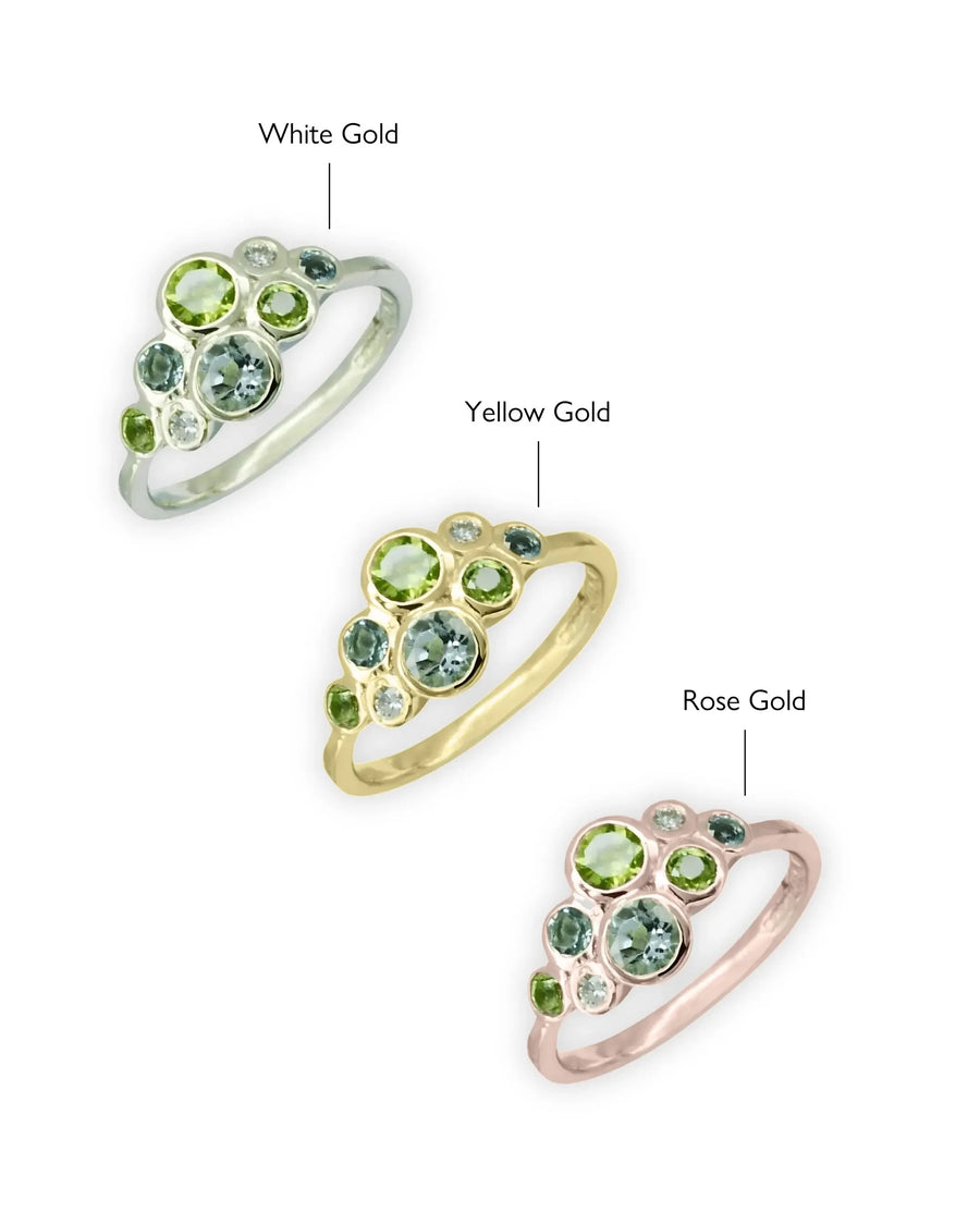 Three family rings in white gold, yellow gold, and rose gold with green and blue gemstones