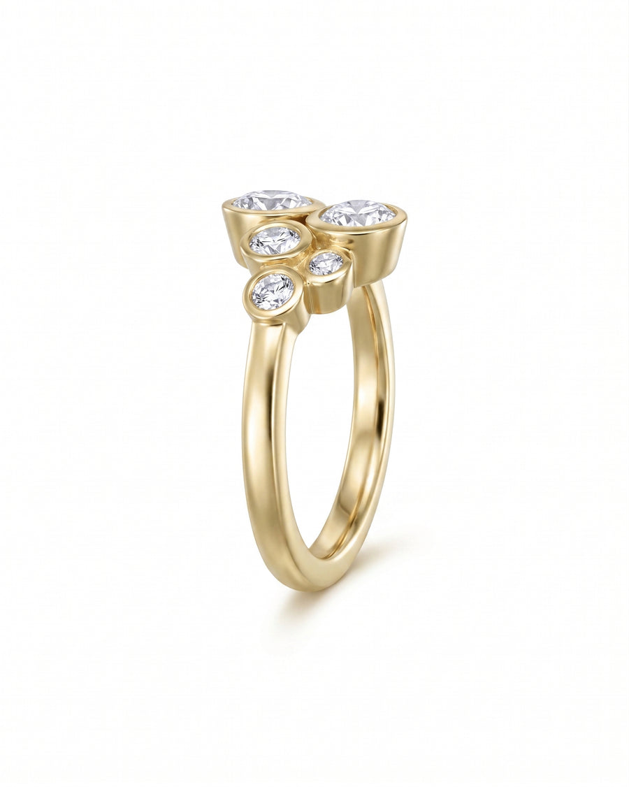Gold ring with five bezel-set round diamonds in a cluster design.