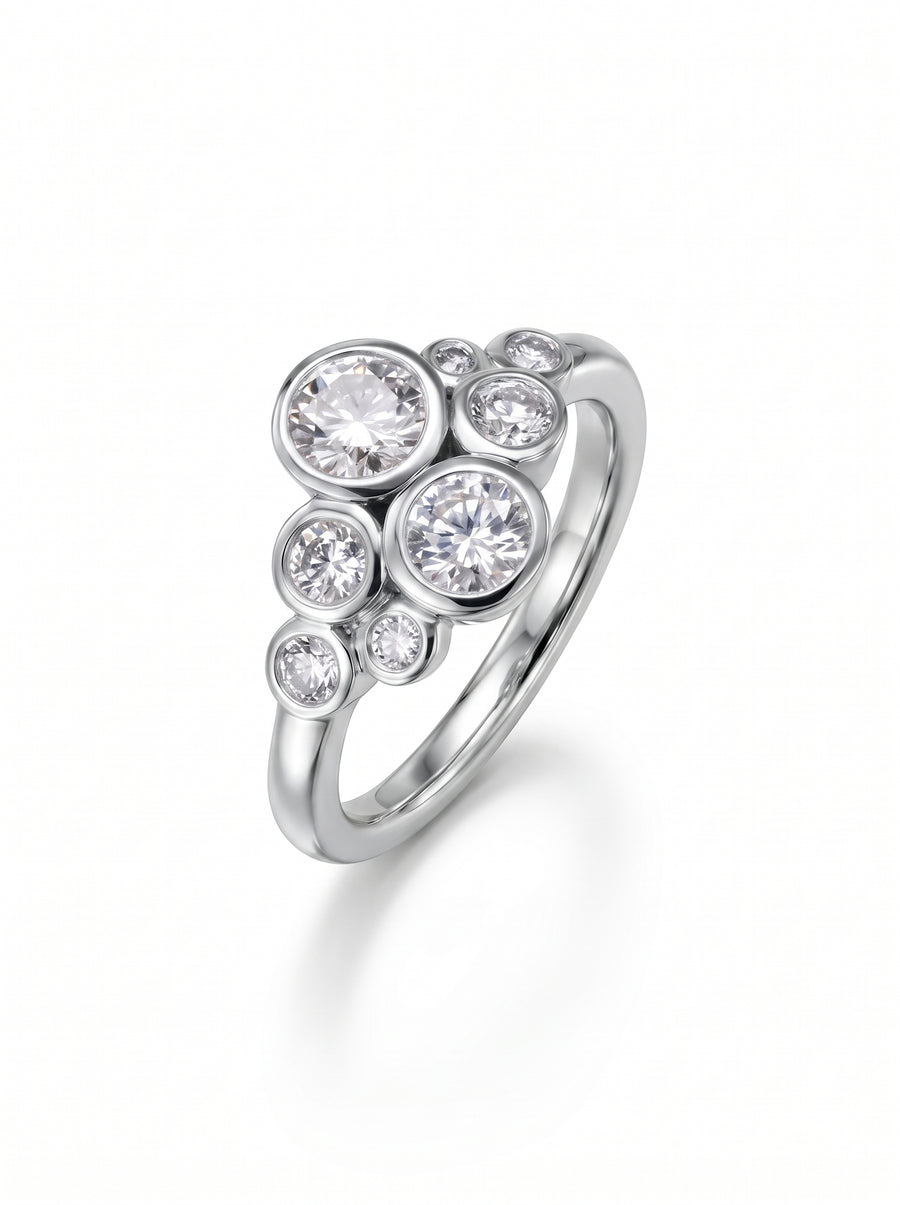 Silver cluster ring featuring multiple round diamonds in bezel settings on a polished band.
