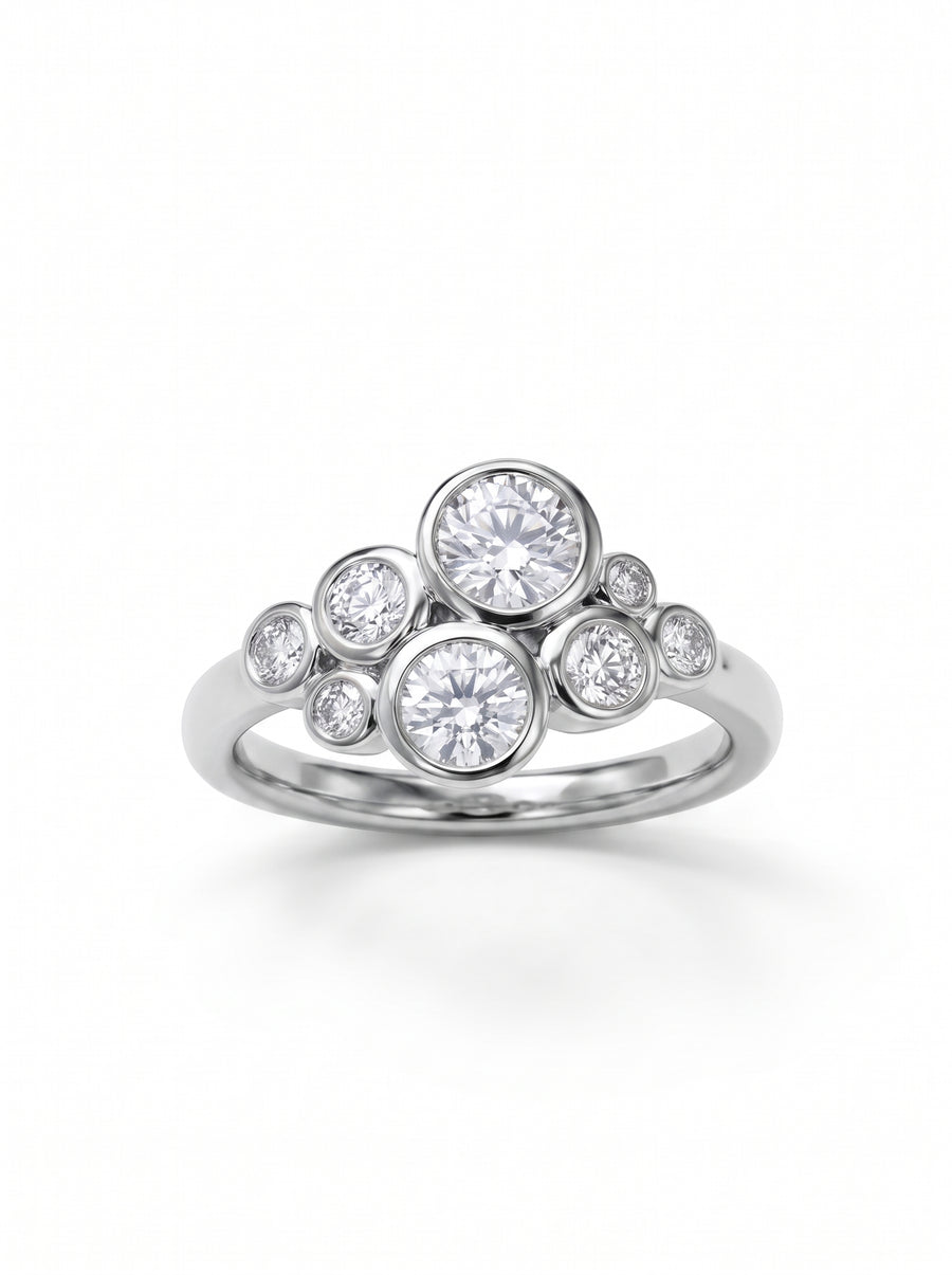Silver cluster ring featuring multiple round brilliant-cut diamonds in bezel settings on a polished band.