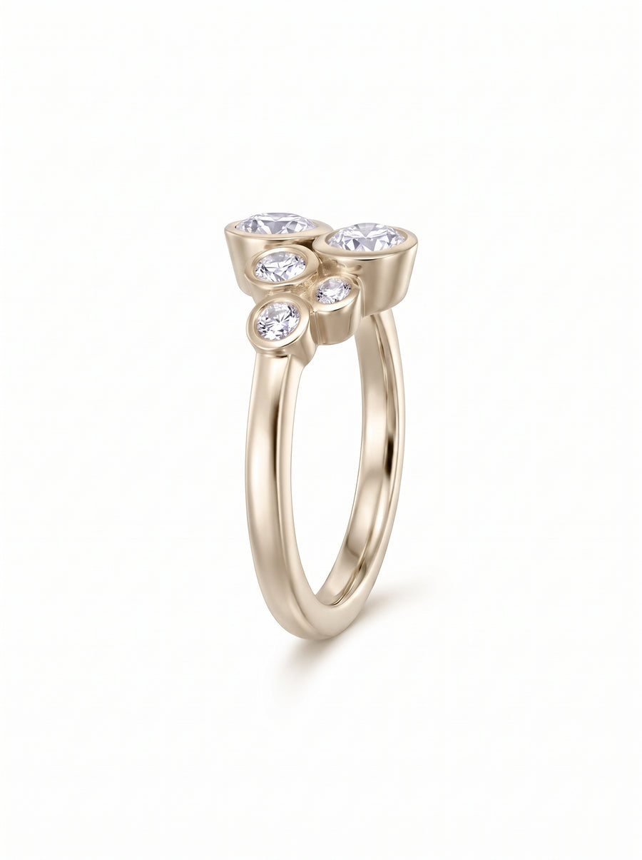 Gold ring featuring a cluster of five round diamonds in bezel settings on a polished band.