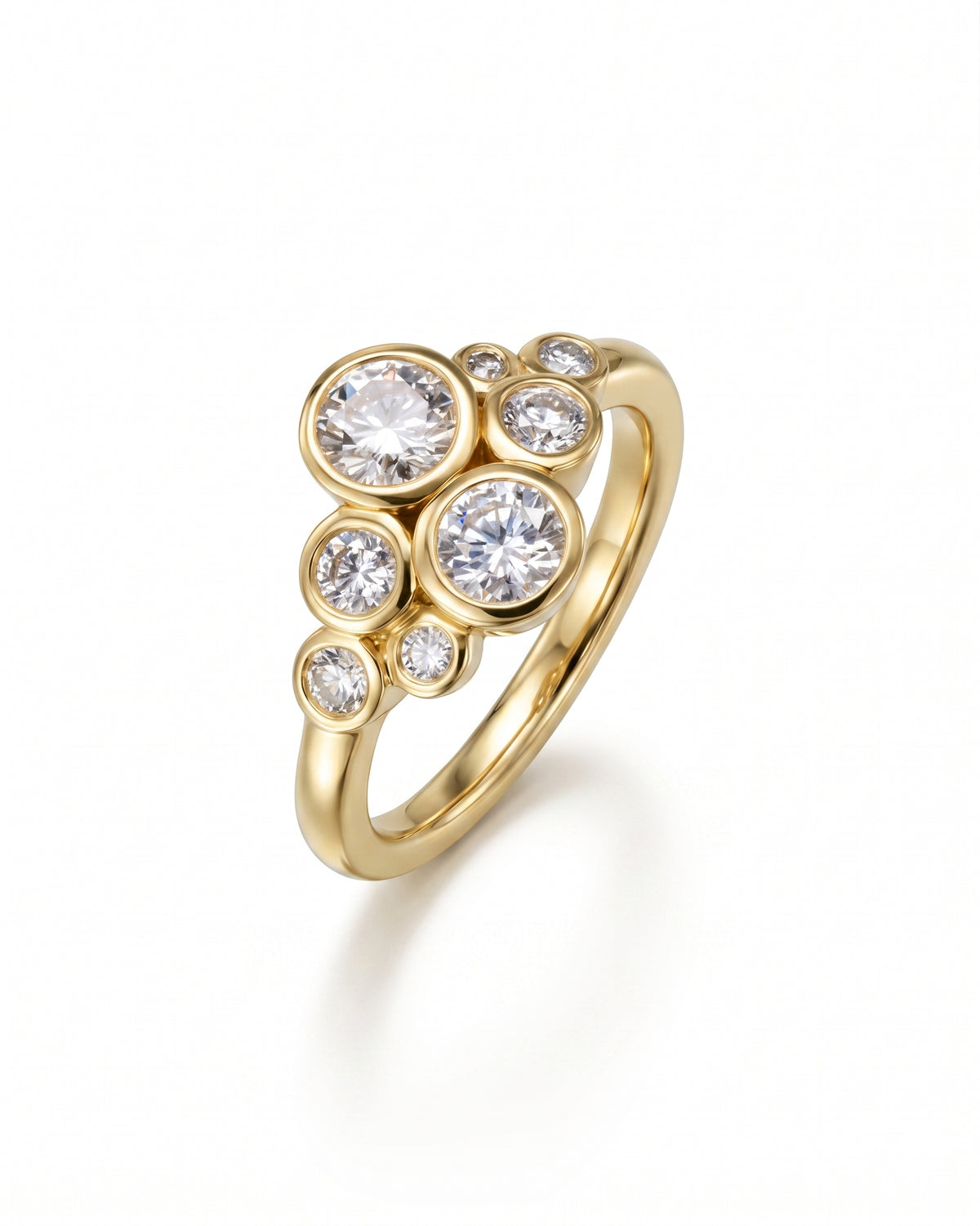 Gold ring featuring a cluster of round brilliant-cut diamonds in bezel settings of varying sizes.