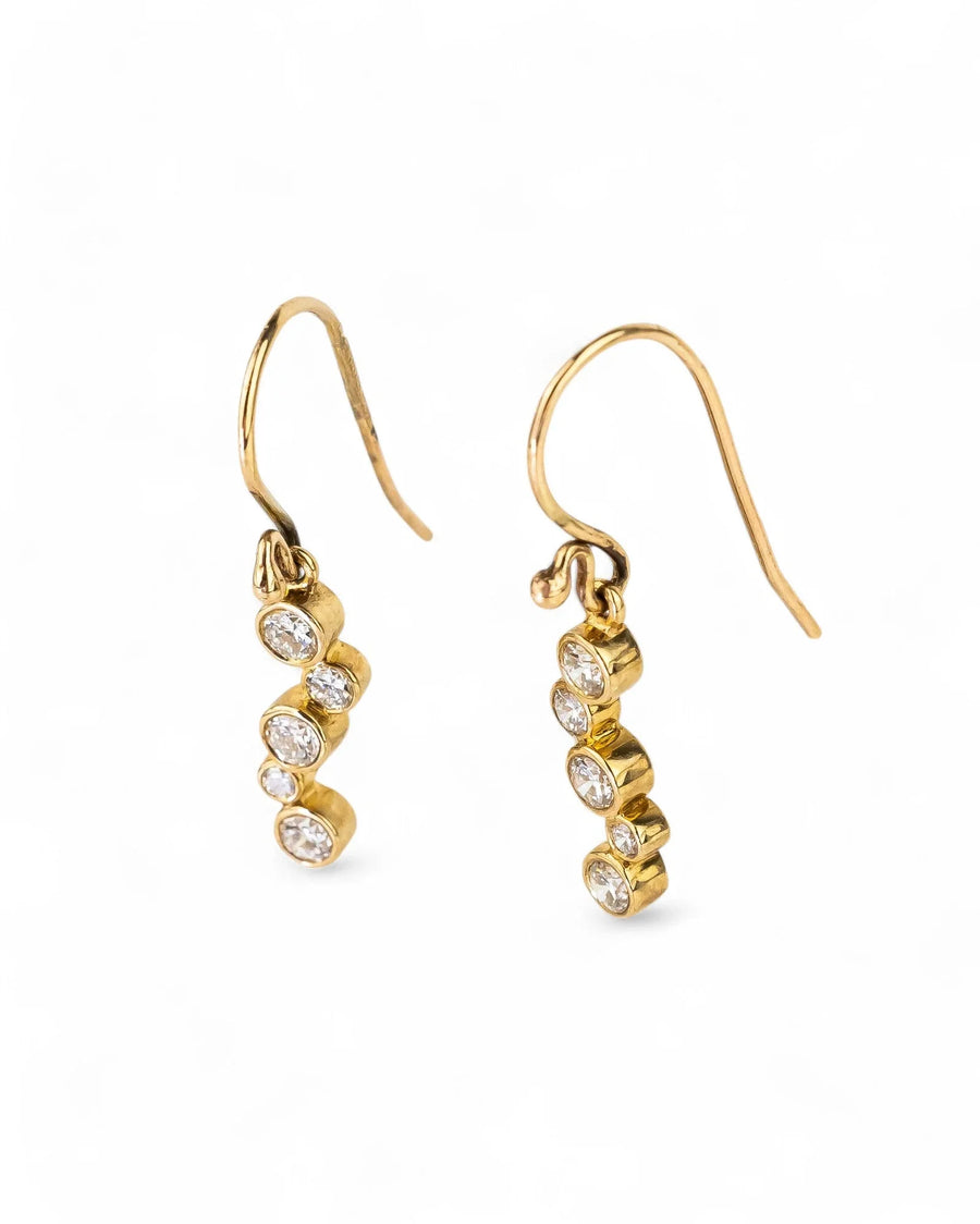 Gold drop earrings with a curved line of round diamonds.