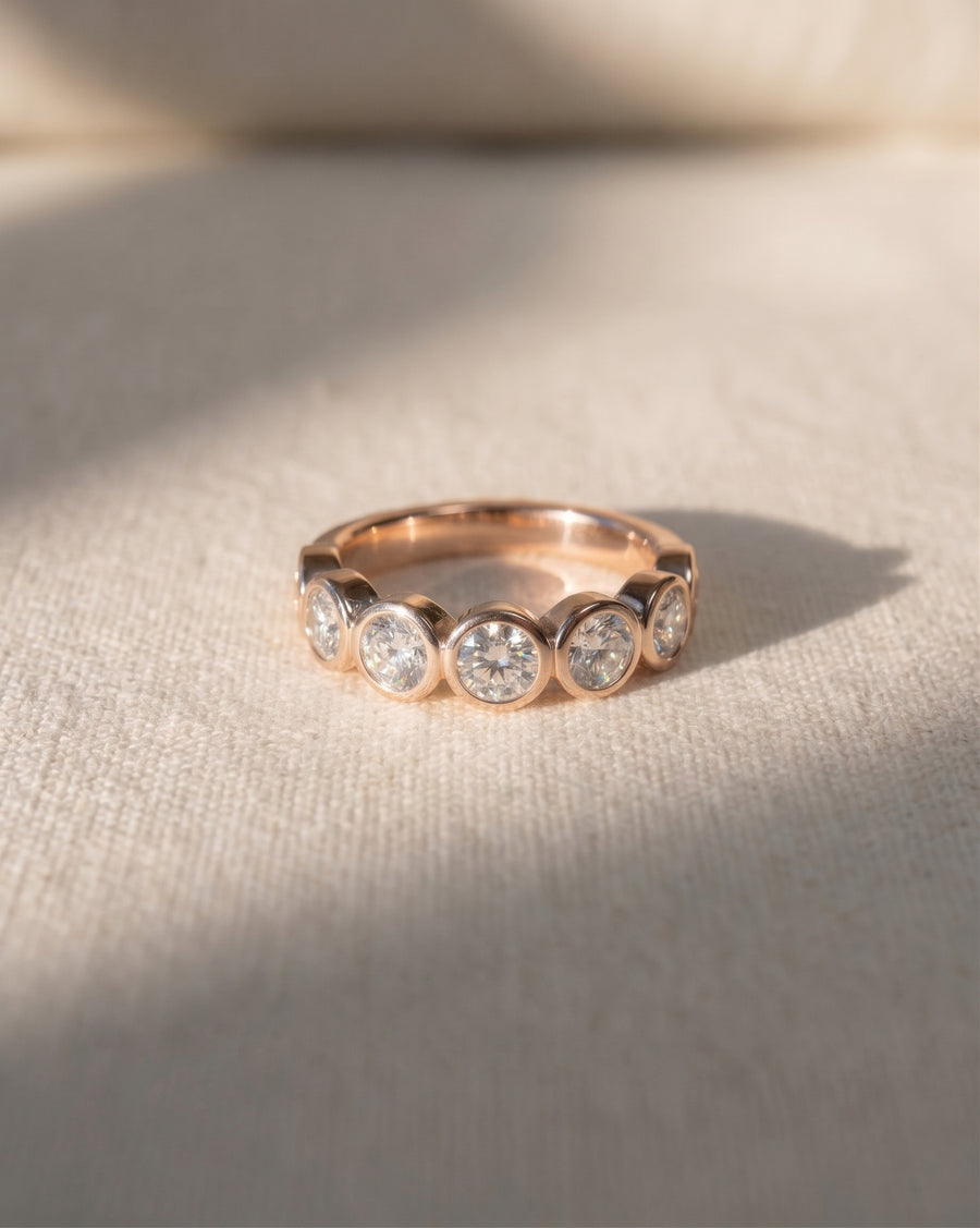 18ct rose gold half eternity ring with bezel-set round diamonds.