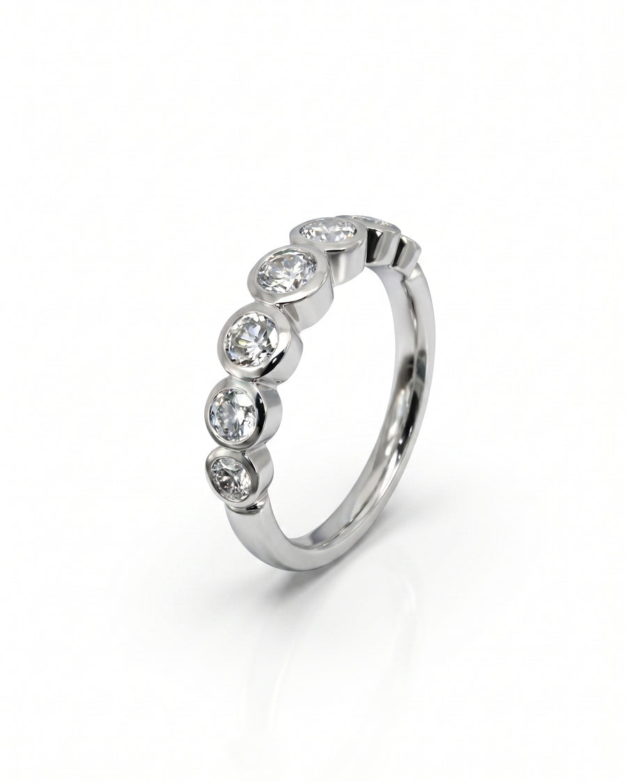 Silver half eternity ring with five bezel-set round diamonds.