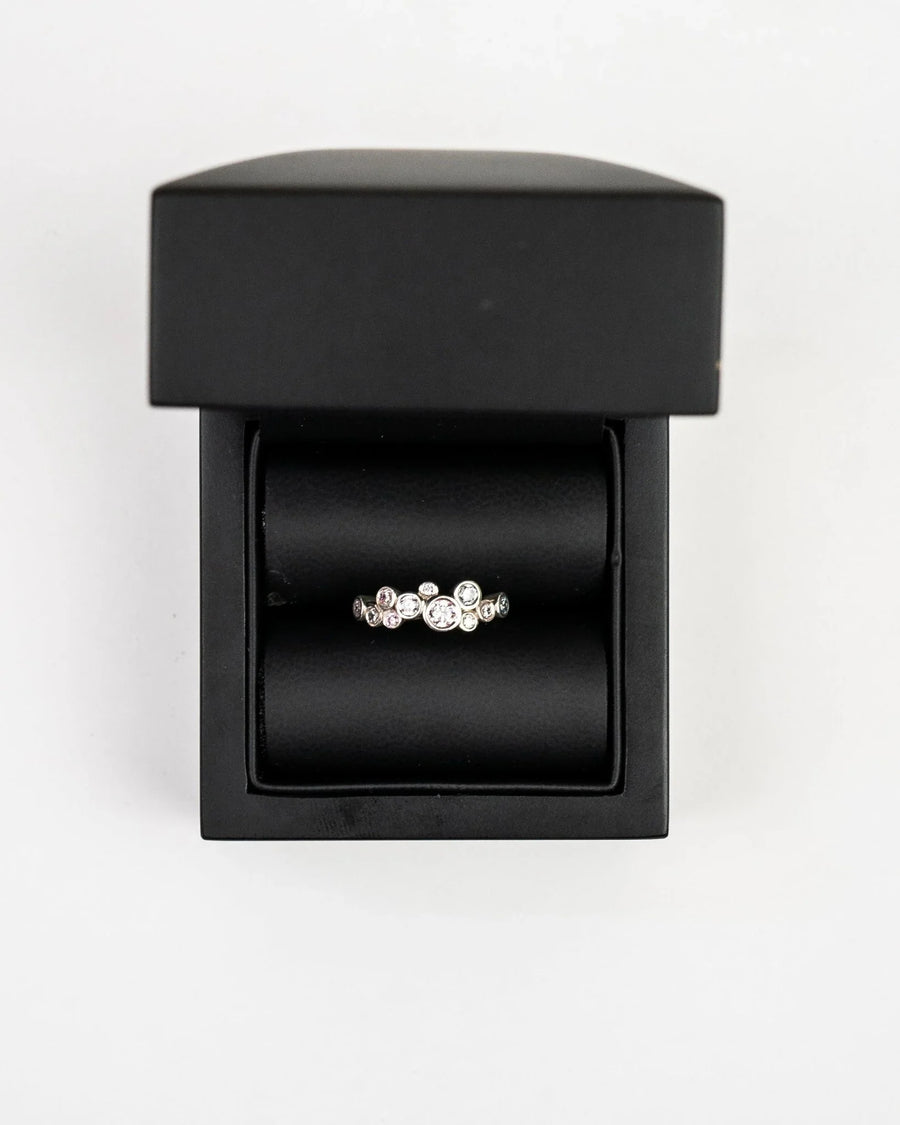 Gold half eternity ring with round diamonds in a bubble design, presented in a black box.
