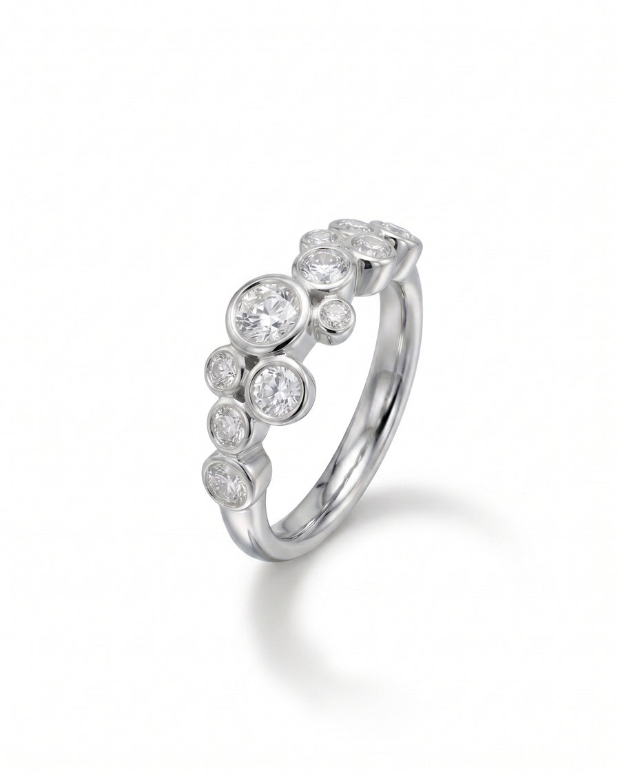 Platinum half eternity ring with scattered round diamonds.