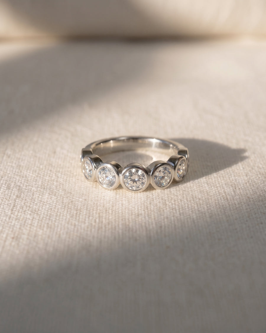 Platinum half eternity ring with round diamonds in bezel settings.