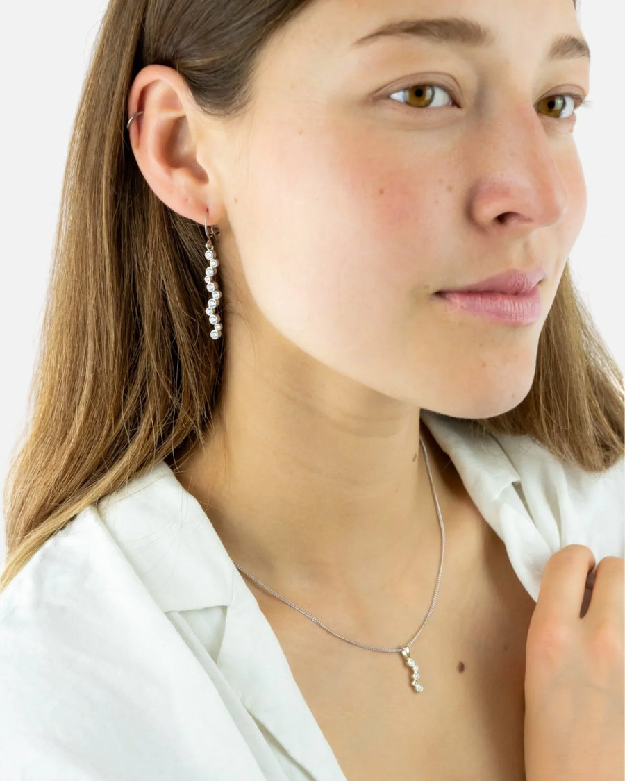 Gold drop earrings with diamonds in a wavy design.