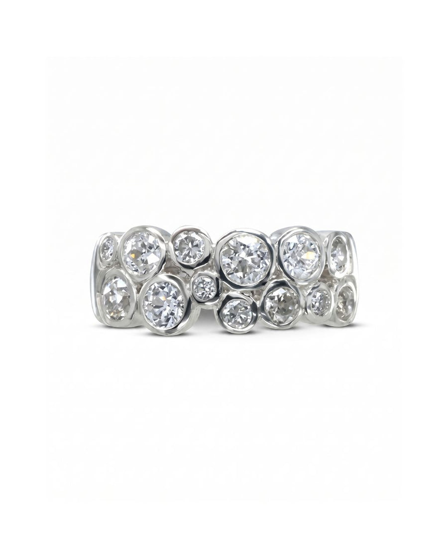 Platinum eternity ring with multiple bezel-set round diamonds in a bubble design.