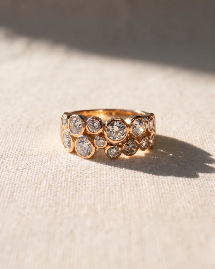 Rose gold eternity ring with bezel-set round diamonds in a bubble design.