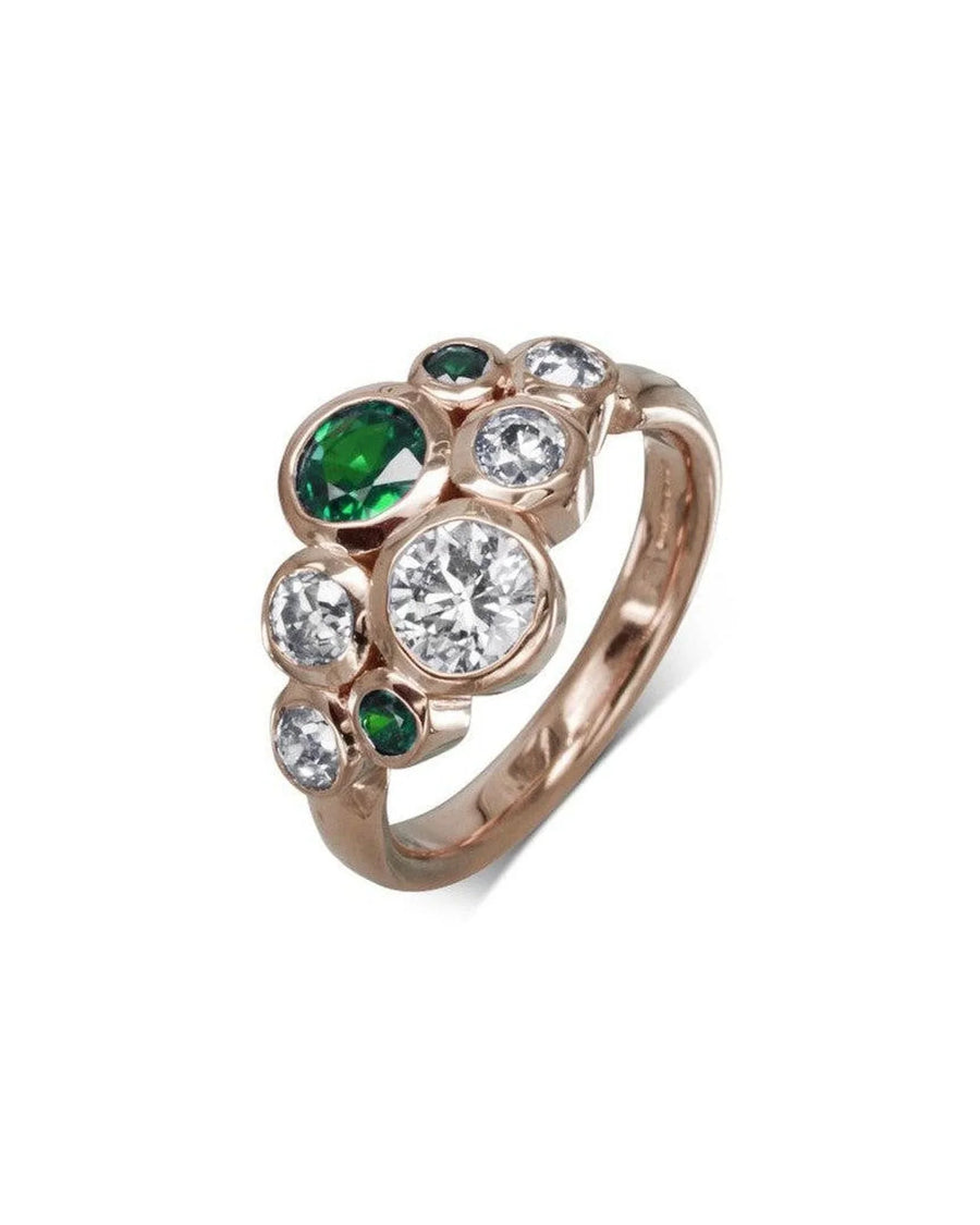 Rose gold ring featuring clustered diamonds and emerald gemstones in organic shapes