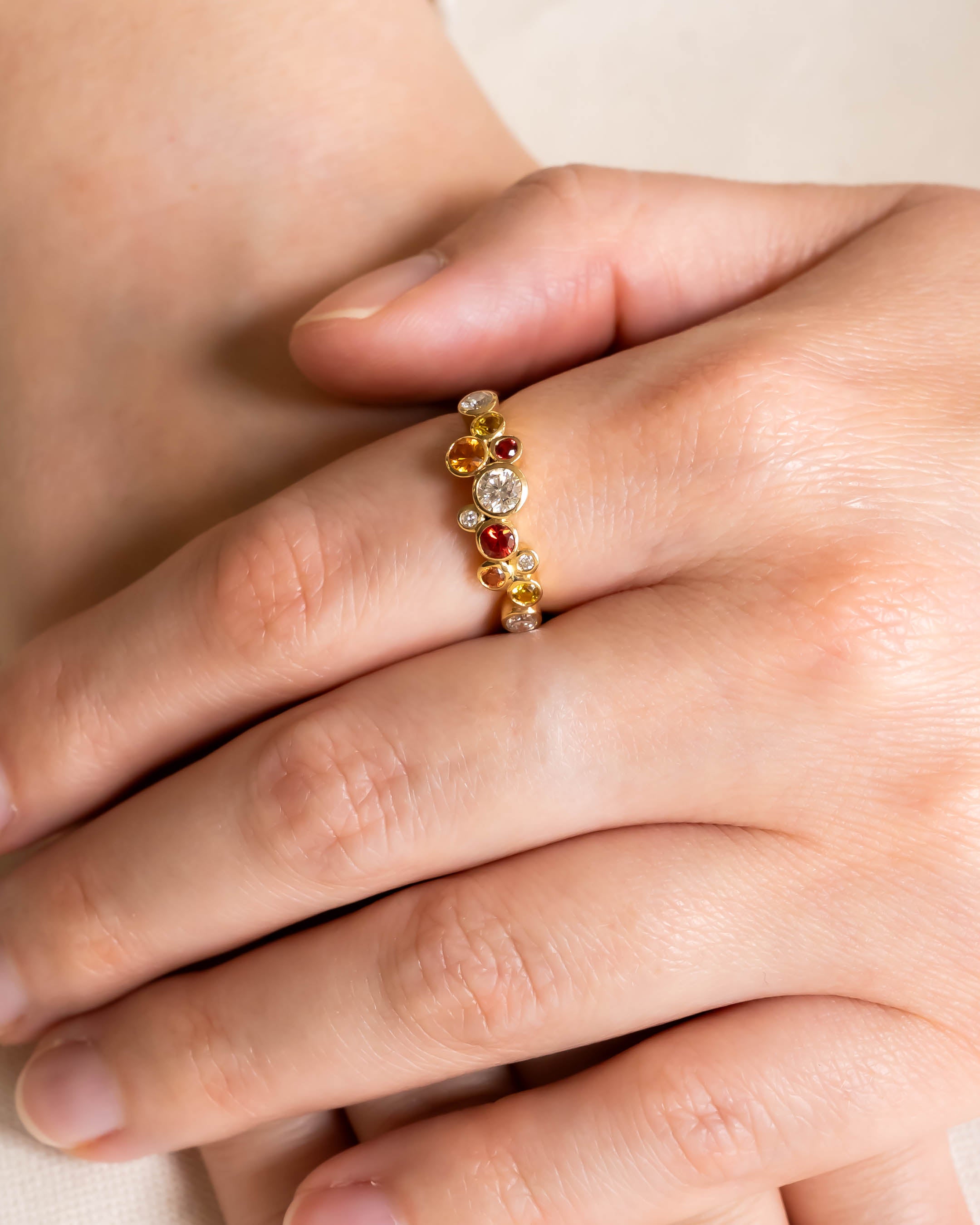 Gold half eternity ring with fire sapphire and diamond bubbles.