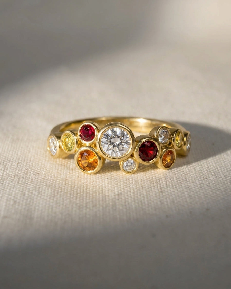 9ct yellow gold half eternity ring with round fire sapphire, diamond, and ruby gemstones.