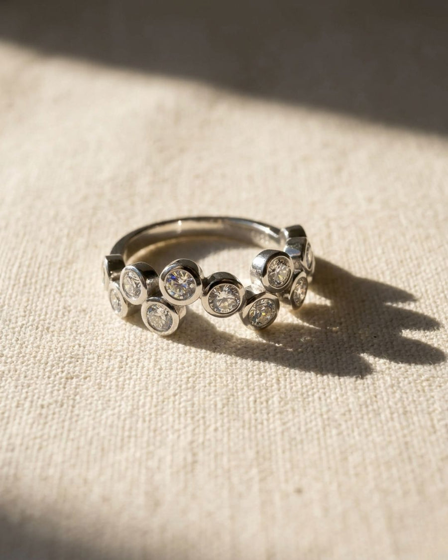 Silver half eternity ring with bezel-set round diamonds in a bubble design.