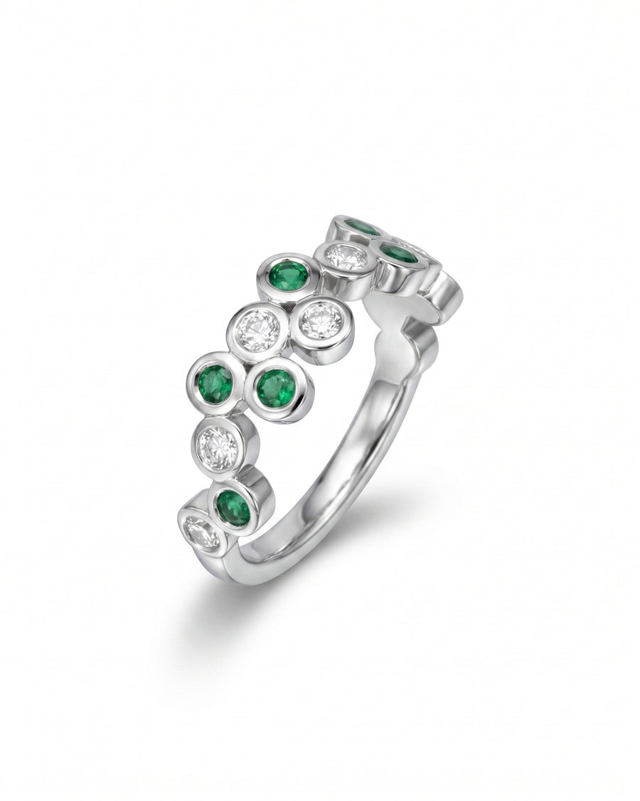 Silver half eternity ring with round emeralds and diamonds in bubble settings.