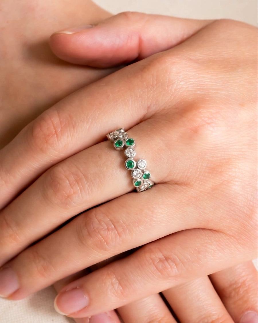 White gold half eternity ring with alternating emerald and diamond bubbles.