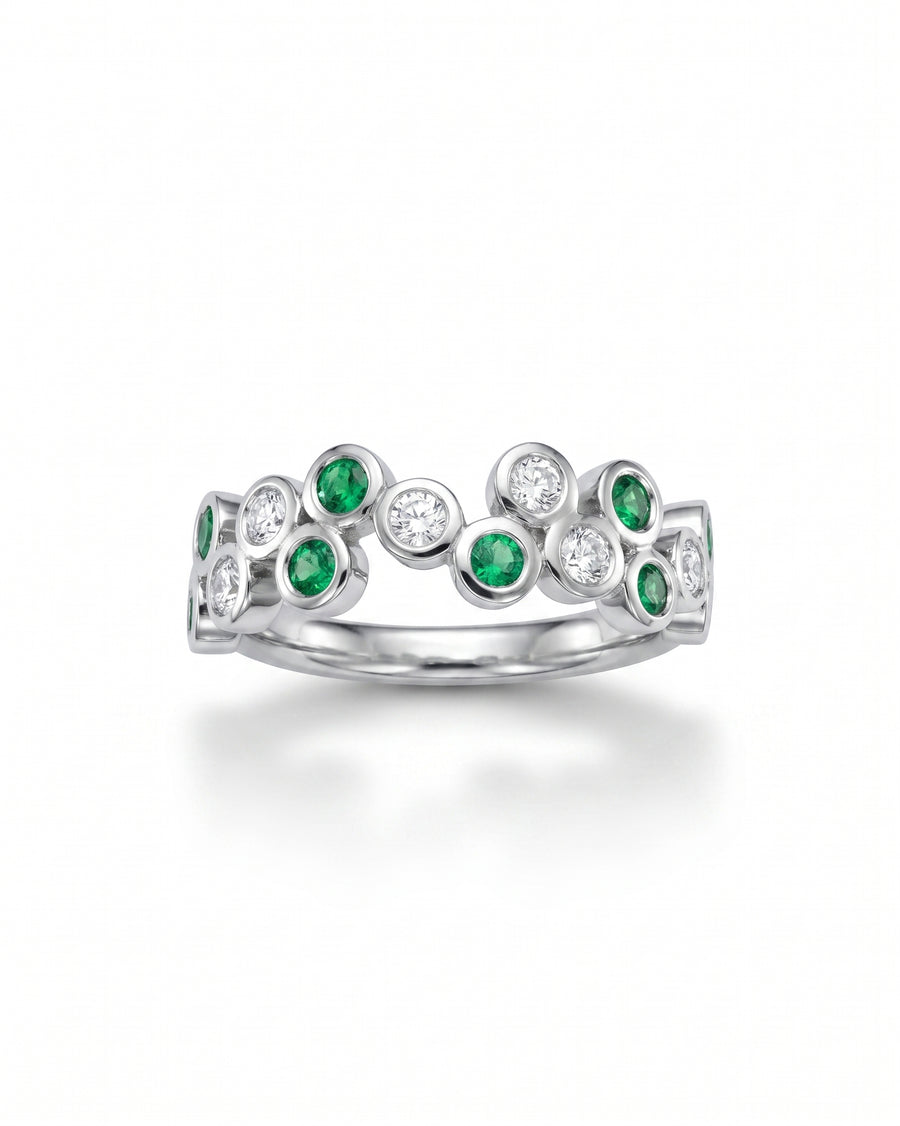 White gold half eternity ring with bezel-set emeralds and diamonds in a bubble design.