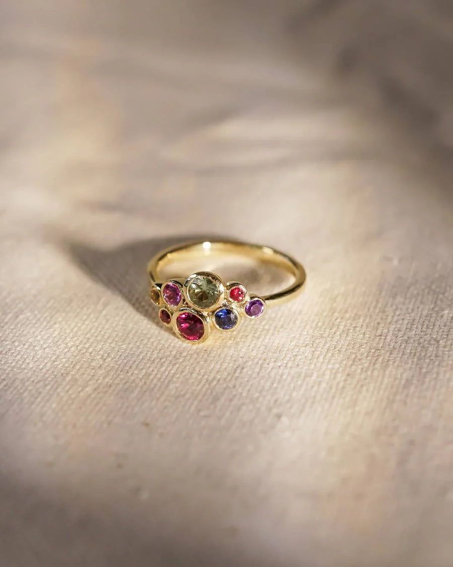 Gold ring with multi-coloured sapphire cluster design.