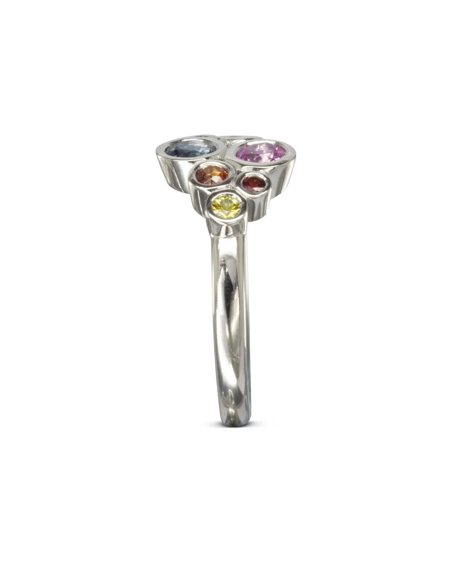 Silver ring with a cluster of multi-coloured sapphire gemstones.