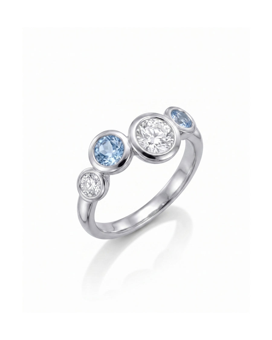 Silver ring with offset aquamarine and diamond gemstones.