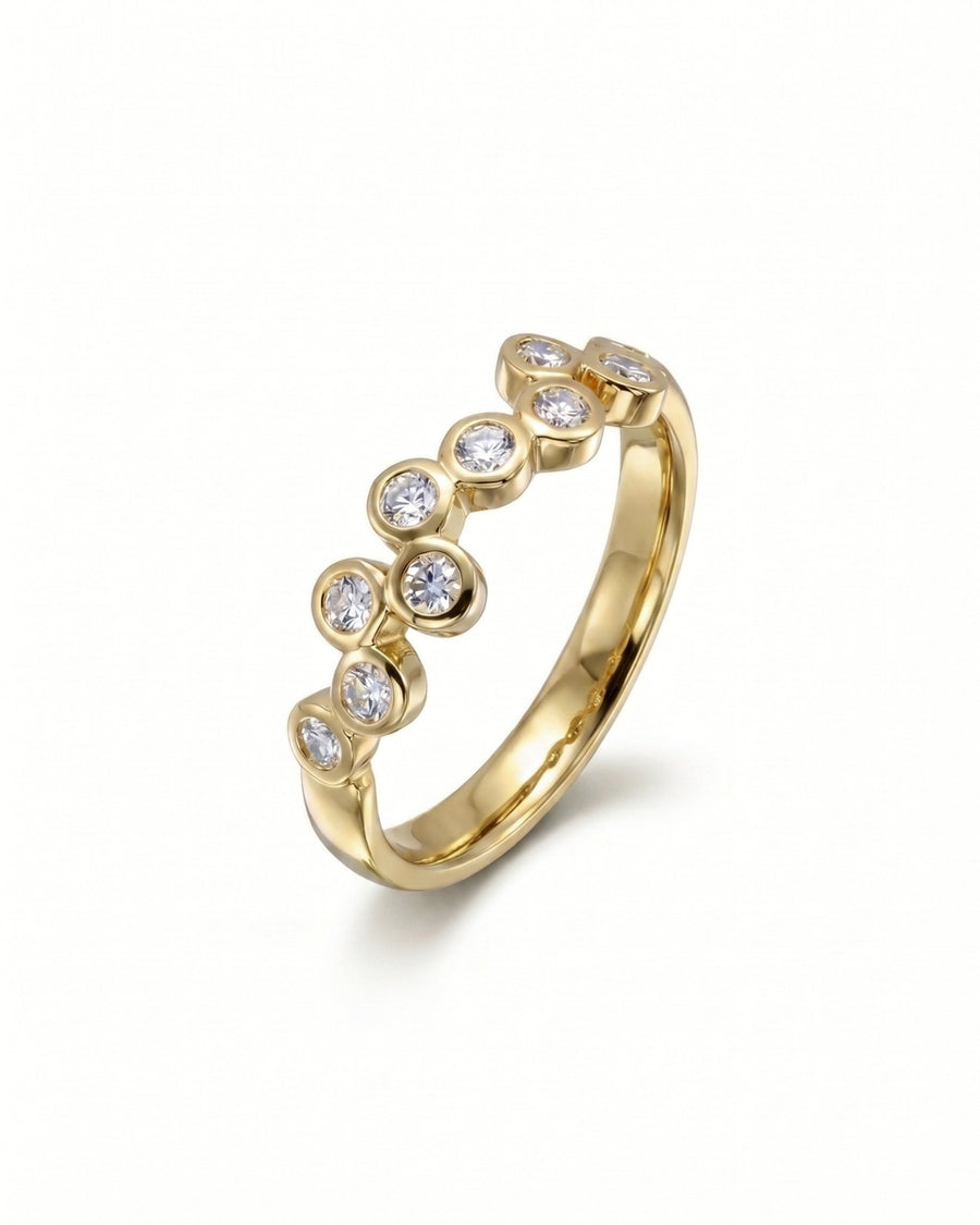 Gold eternity ring with offset round diamonds in bubble settings.