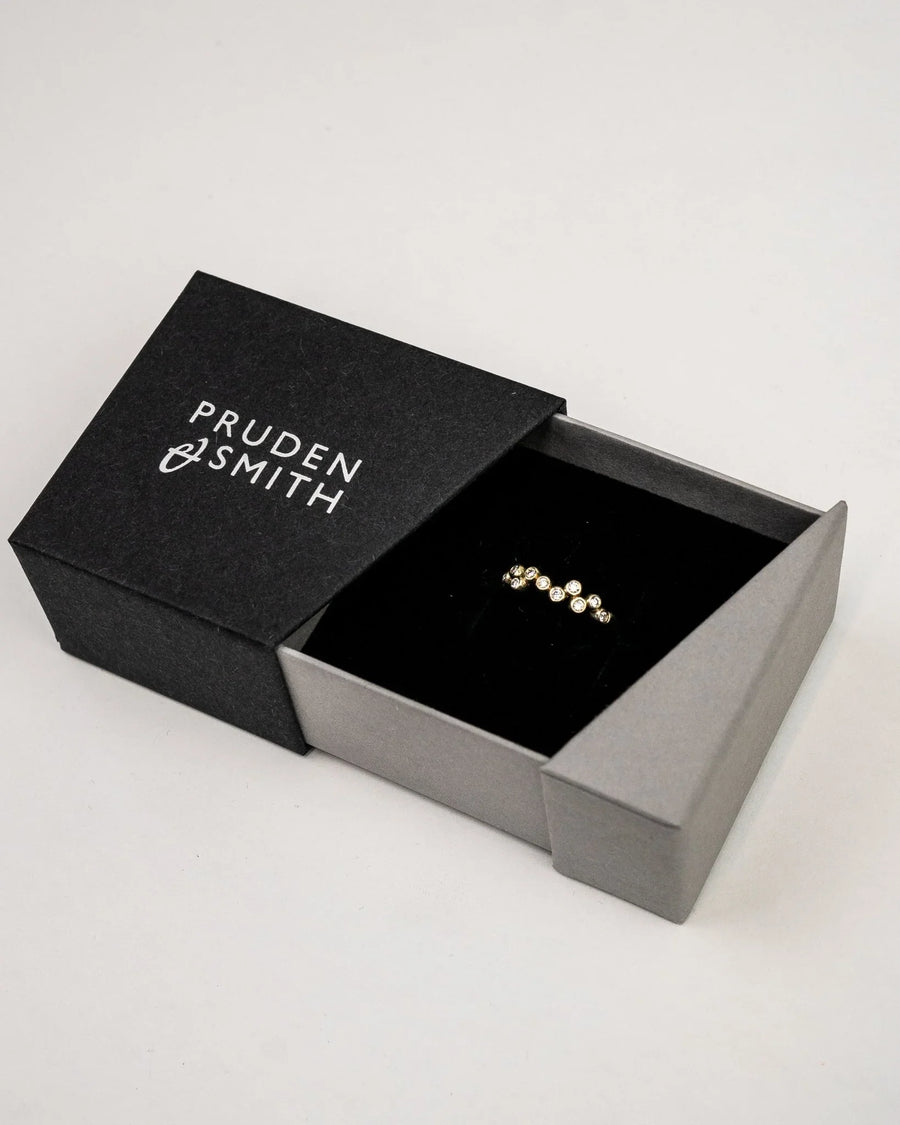 Gold Bubbles Offset Diamond Eternity Ring in a black and gray box.