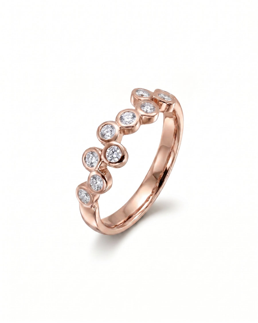 9ct rose gold eternity ring with offset bezel-set diamonds.