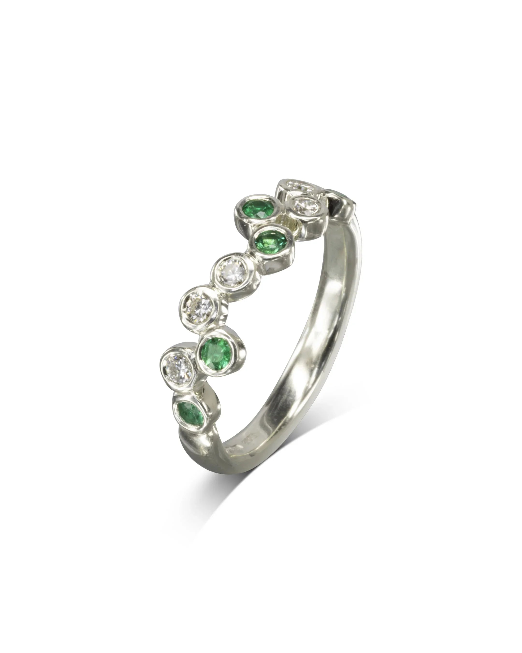 9ct white gold half eternity ring with offset emerald and diamond gemstones.