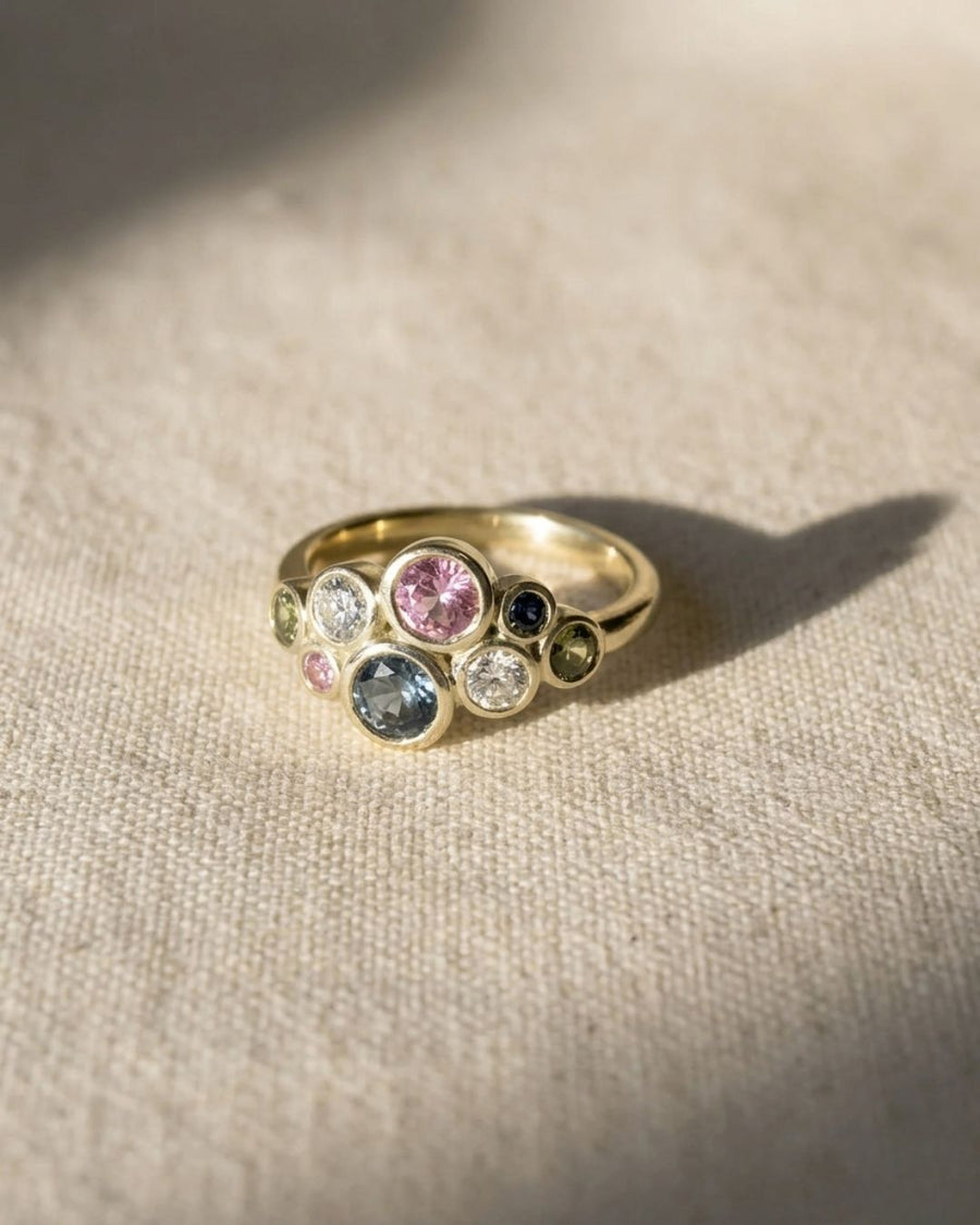 Gold cluster ring with pink, teal, and white sapphires.