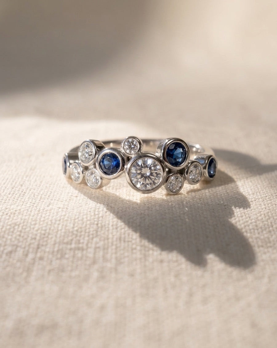 White gold eternity ring with random sapphire and diamond gemstones.