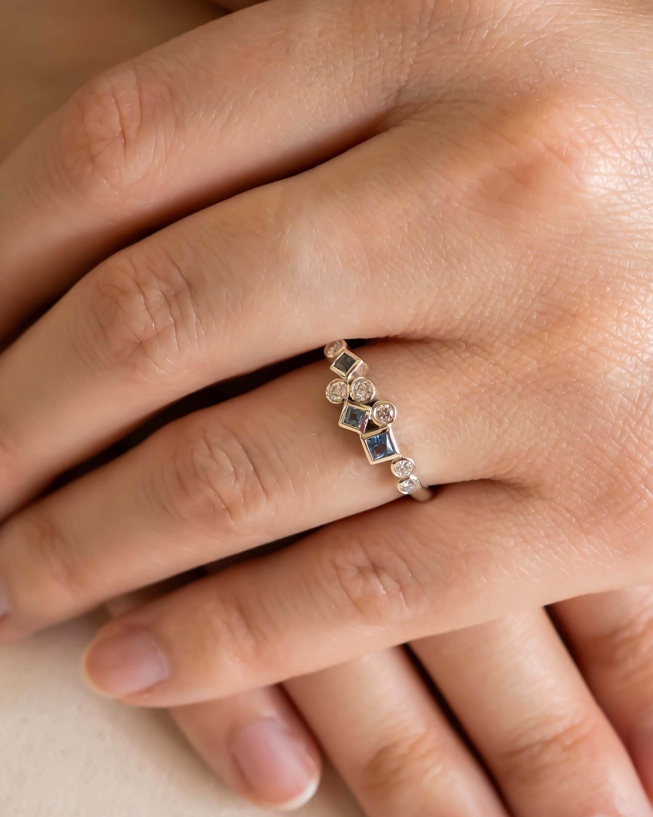 Gold half eternity ring with aquamarine and diamond gemstones.