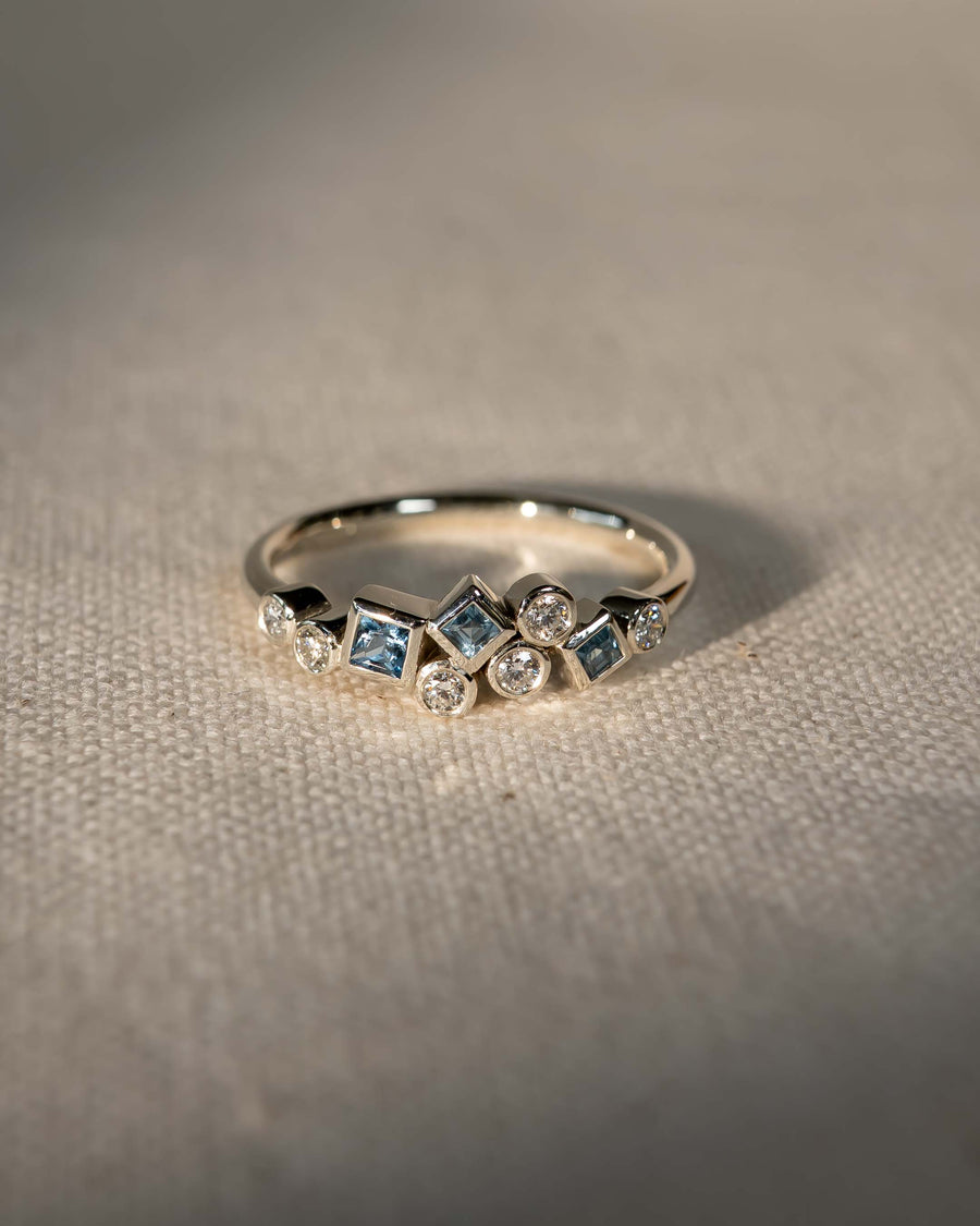 Silver half eternity ring with aquamarine and diamond gemstones.