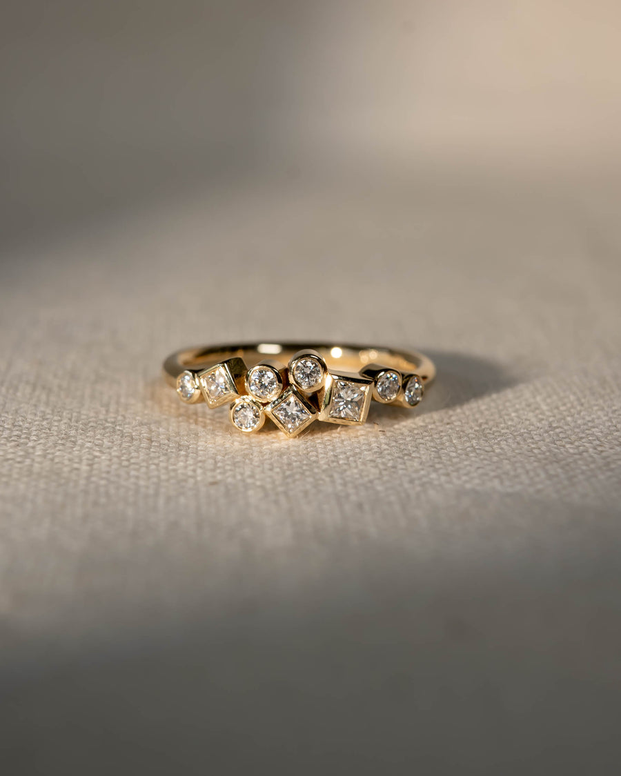 Gold ring with scattered round and square diamonds.