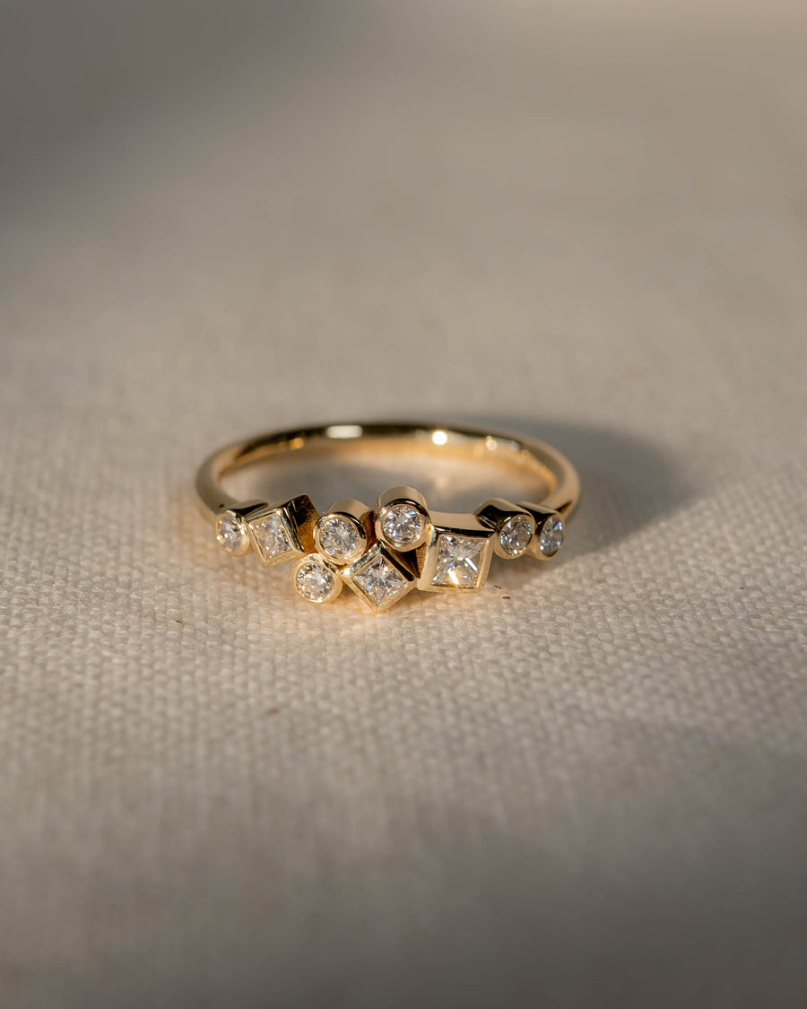 Gold ring with scattered round and square diamonds.