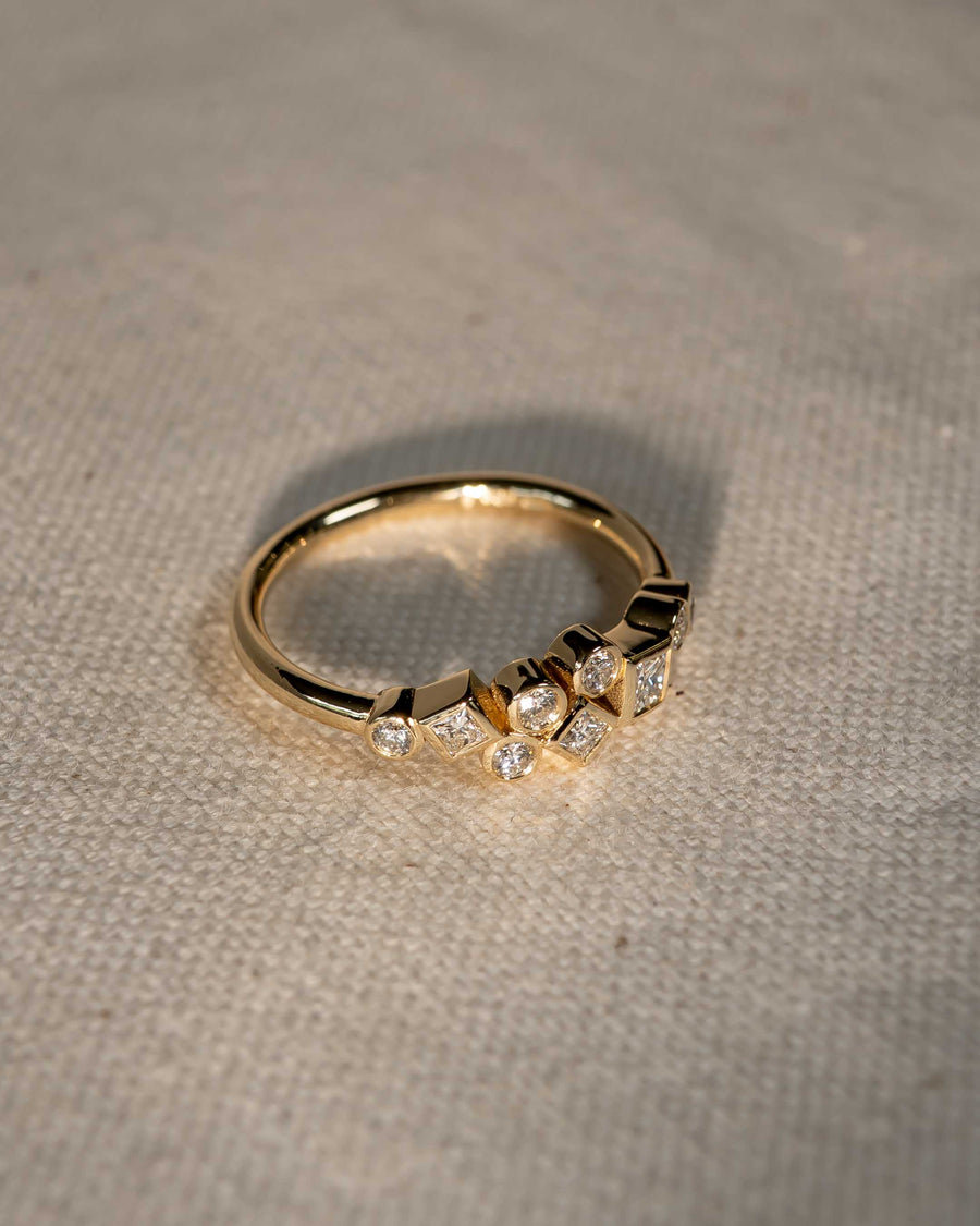 Gold ring with scattered round and square diamonds.