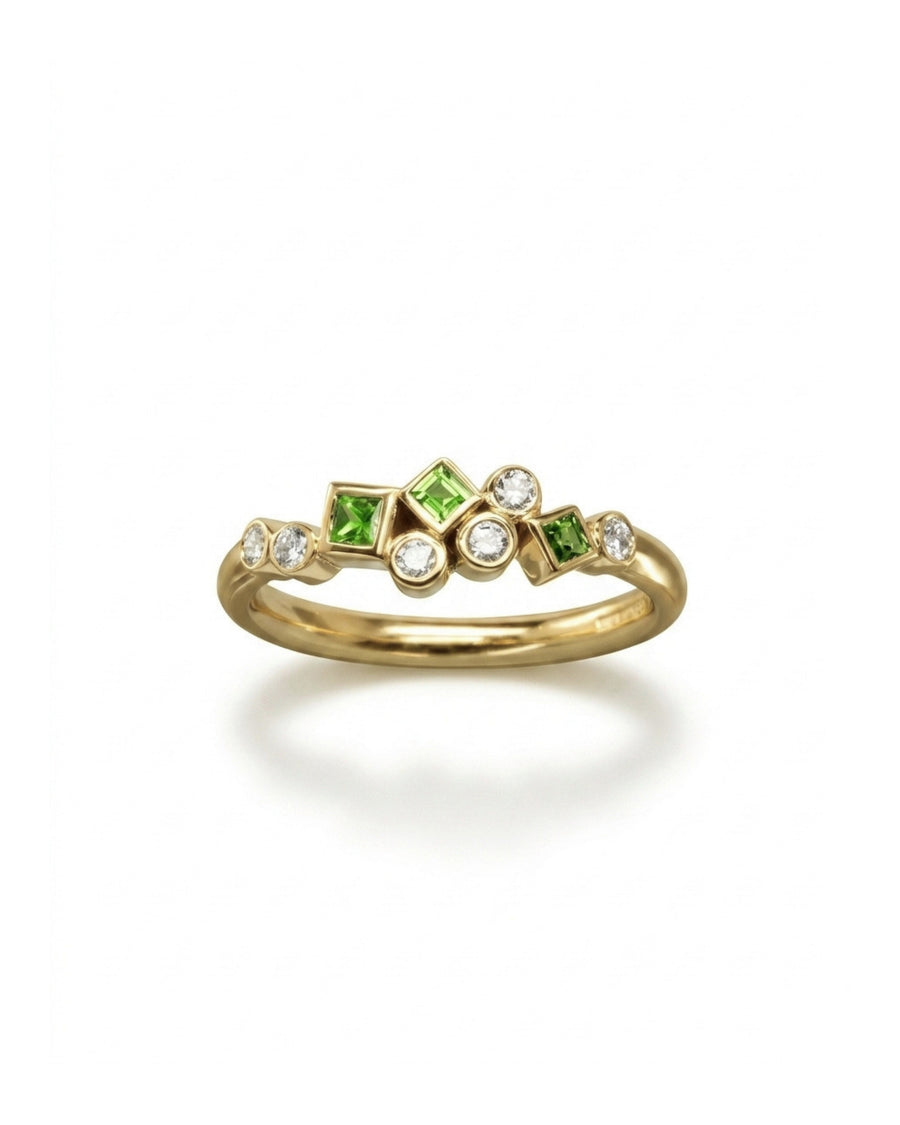 Gold half eternity ring featuring a cluster of round diamonds and square-cut green gemstones.