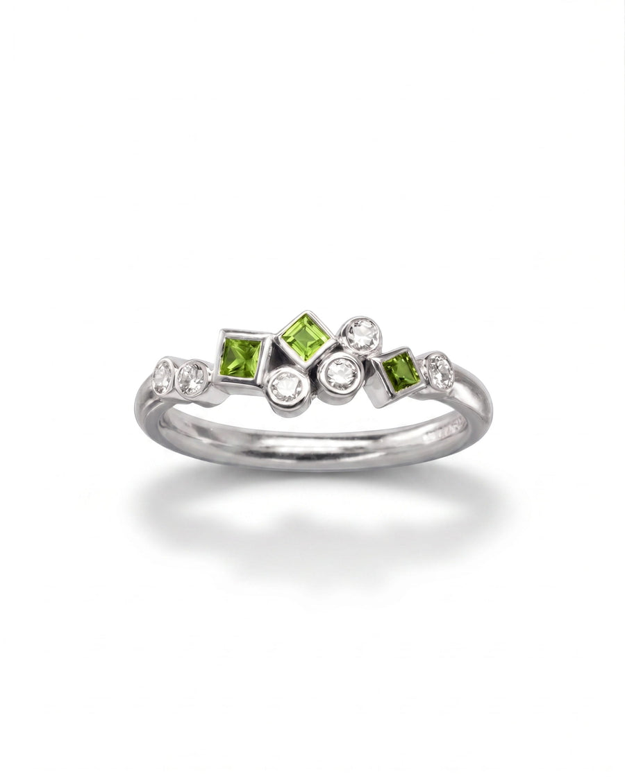 9ct white gold half eternity ring featuring a cluster of square-cut green emeralds and round white diamonds.