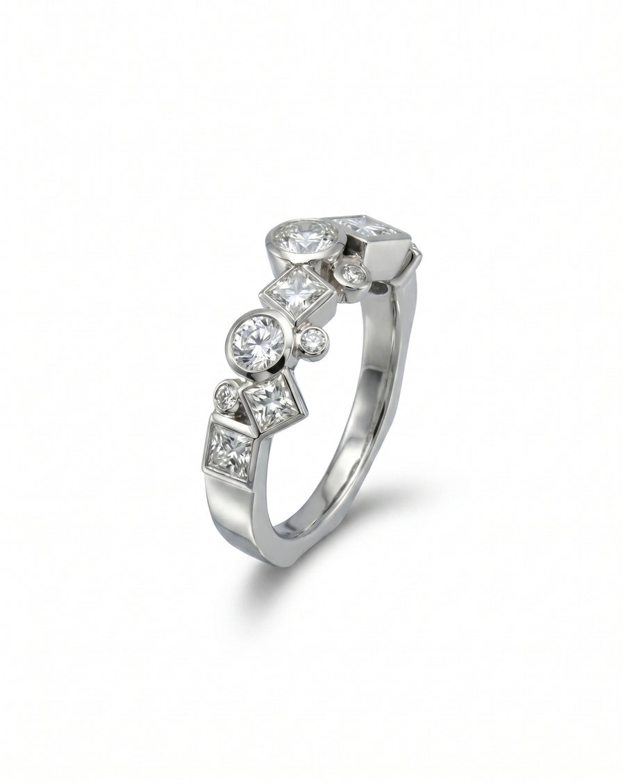 Silver ring with round and square cut diamonds in a unique, scattered design.