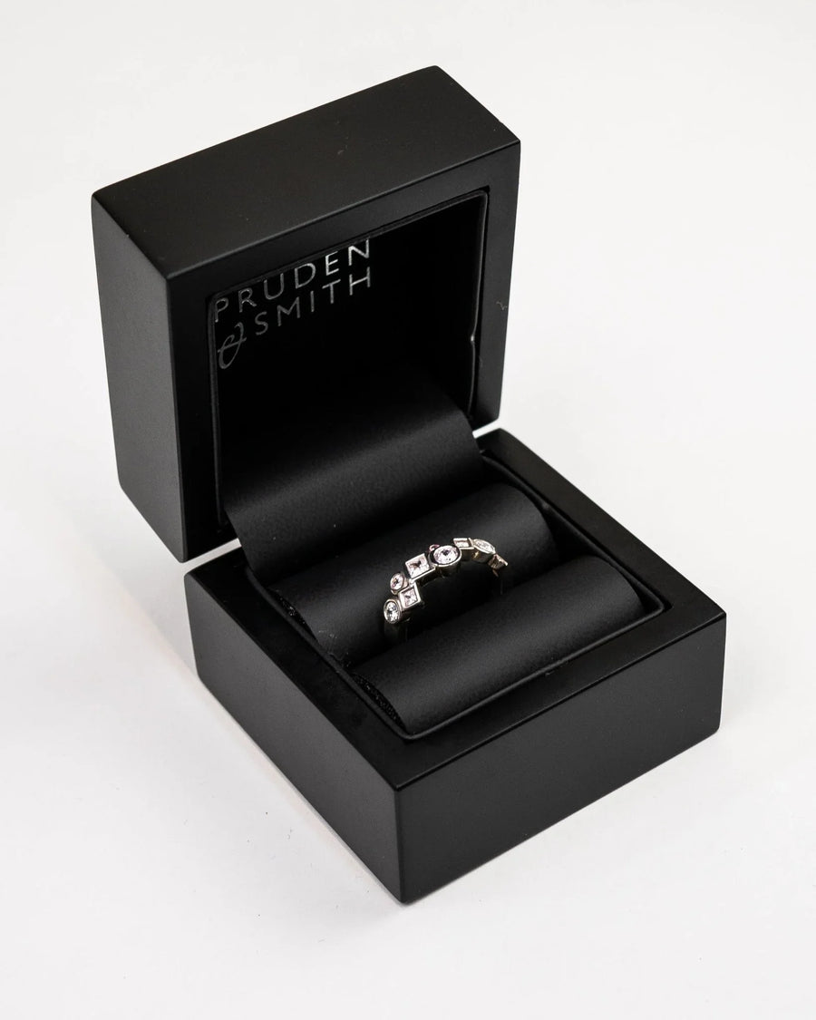 Gold ring with varied shape diamonds in a black box.