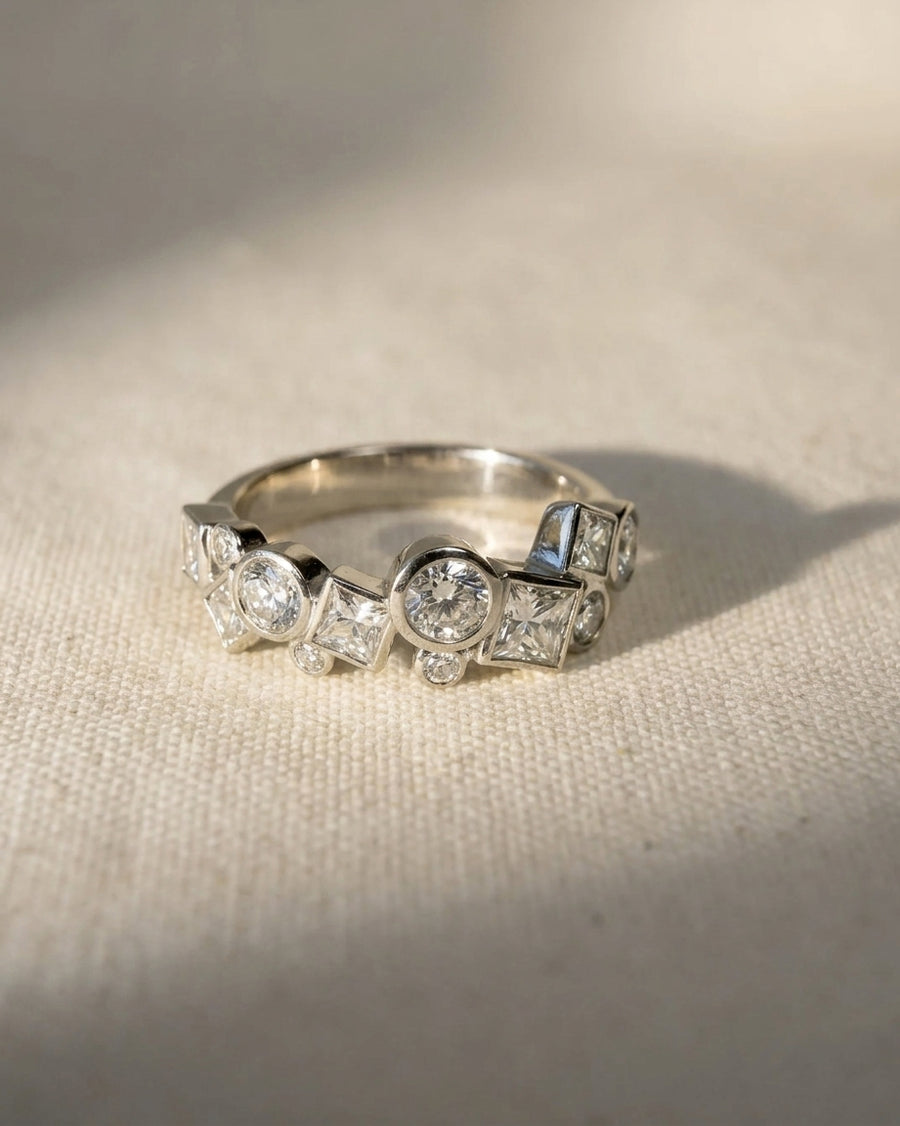 Platinum ring with round and square cut diamonds in a unique, scattered design.