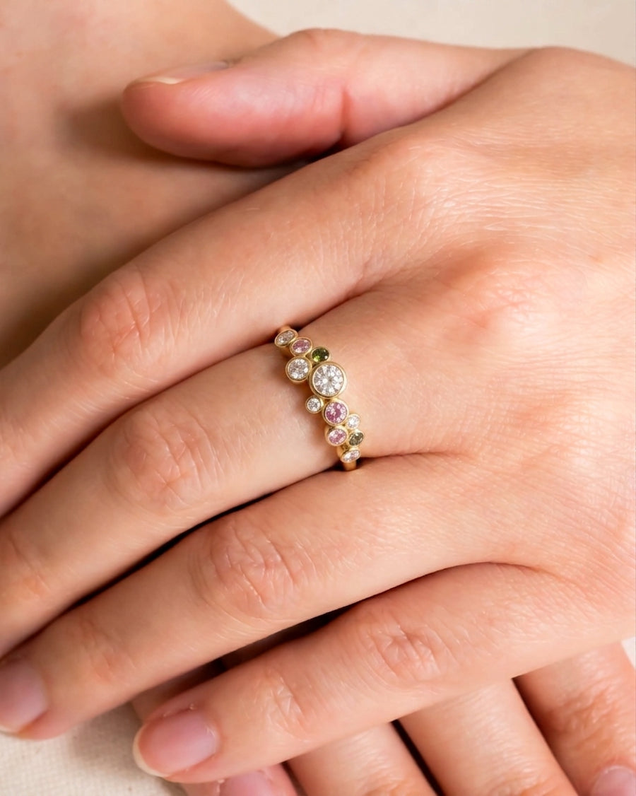 Gold half eternity ring with sapphire, diamond, and tourmaline gemstones.