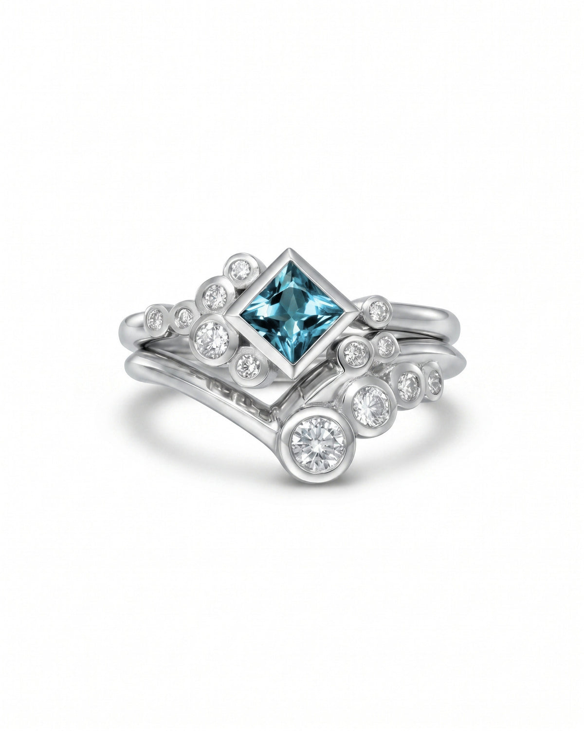 Silver ring set featuring a square aquamarine center stone surrounded by round diamonds in a bubble design.