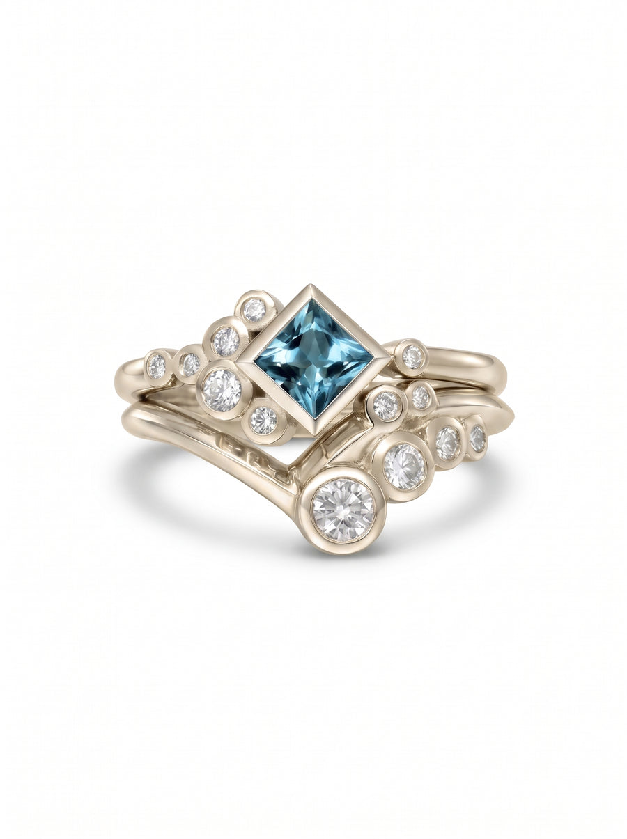 Square aquamarine and diamond ring set in white gold with a bubble-inspired cluster design.