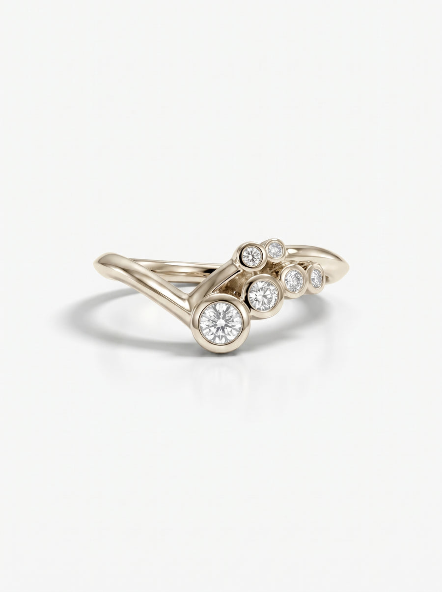 Gold ring featuring a cluster of five round diamonds in a bezel setting on a V-shaped band.
