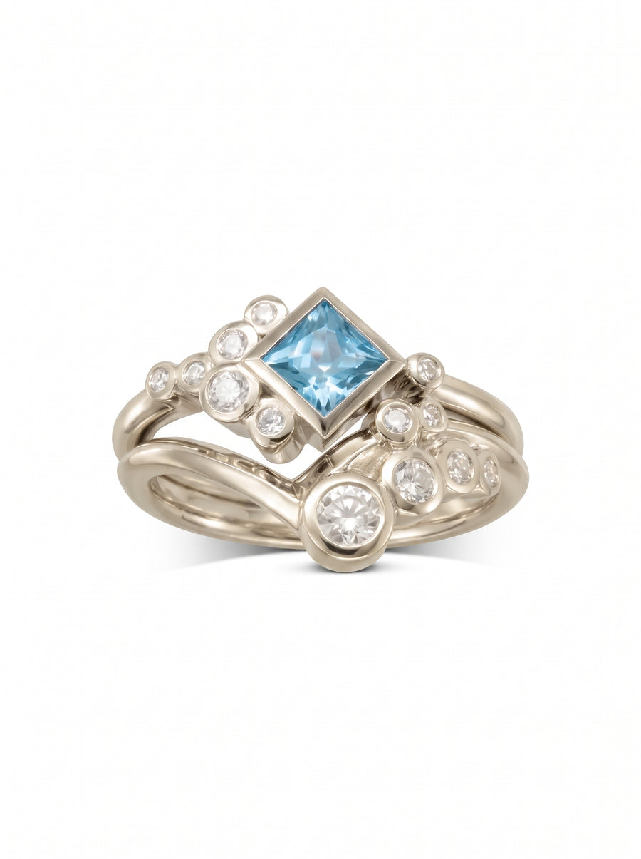 Square aquamarine and diamond ring set in silver metal with a bubble-inspired cluster design.