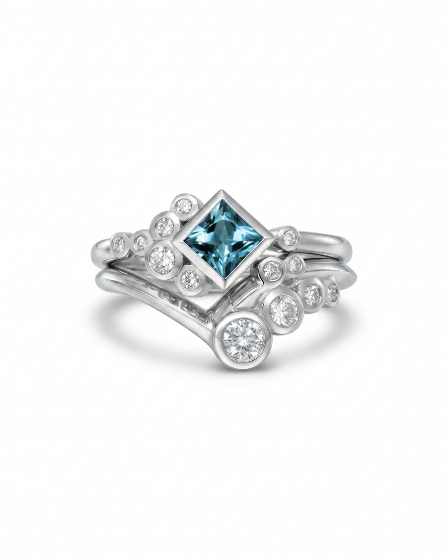Silver ring set with a square aquamarine and round diamonds in a bubble design.