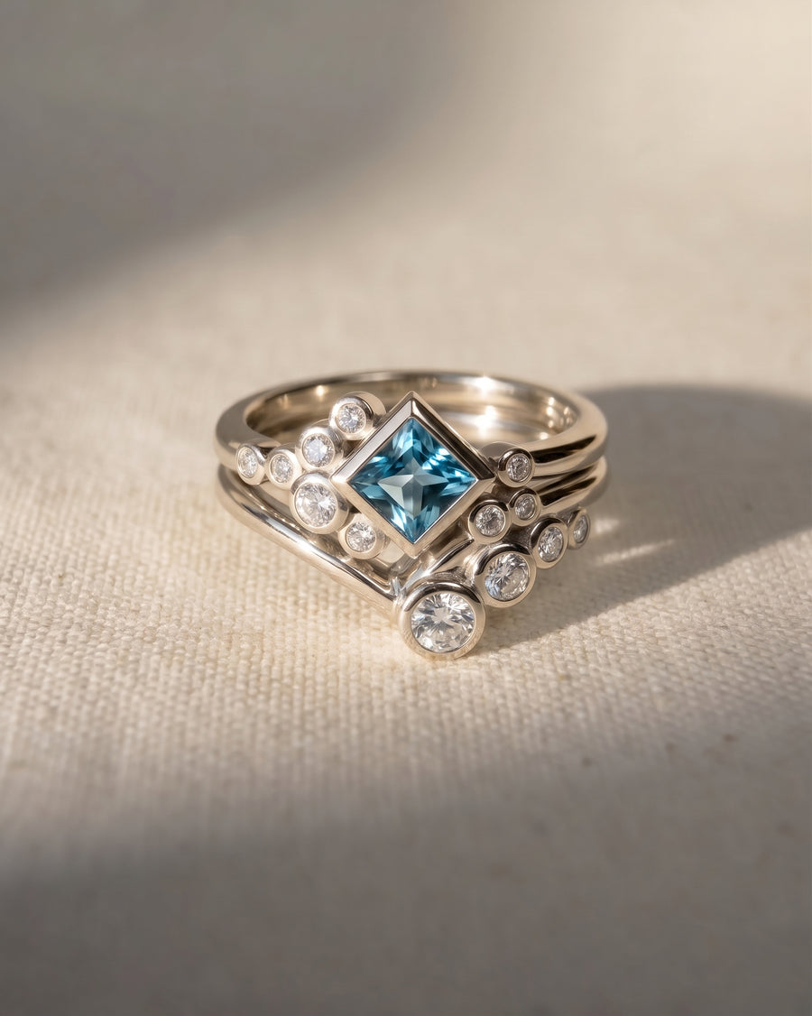 9ct white gold ring set with a square aquamarine and round diamonds.