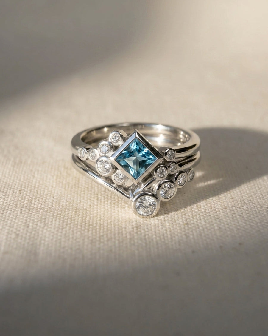 Platinum ring set with a square aquamarine and round diamonds.
